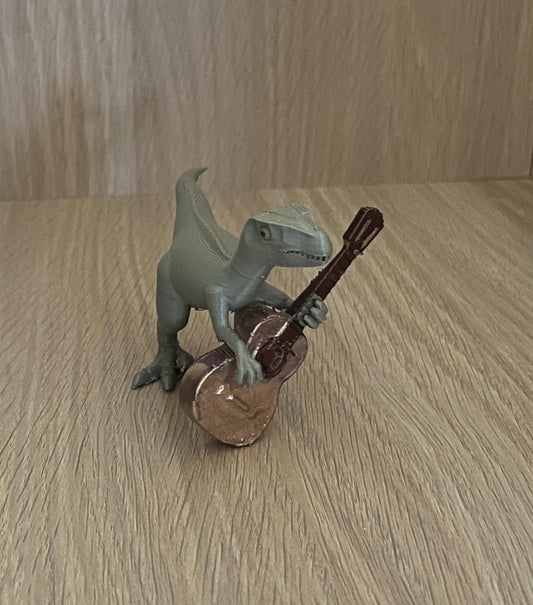 Velociraptor met gitaar beeldje